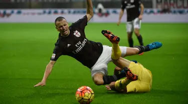 Bek AC Milan, Luca Antonelli (kiri) berusaha merebut bola dari kawalan gelandang Chievo, Giampiero Pinzi pada laga serie A di stadion San Siro, Italia (28/10/2015). AC Milan menang atas Chievo dengan skor 1-0. (AFP PHOTO/OLIVIER MORIN)