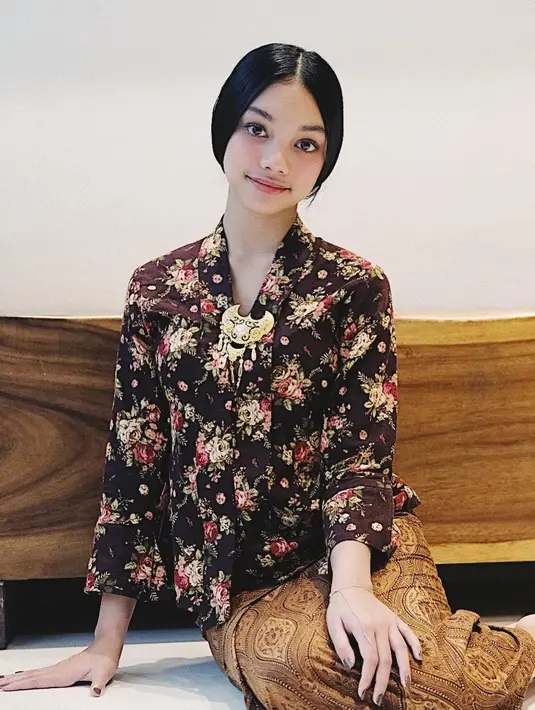 Naura Ayu tampil anggun dengan kebaya kartini motif floral yang apik. Makin manis dengan aksesori bros yang dikenakannya, sementara kain batik coklat digunakan sebagai bawahan. [@naura.ayu].