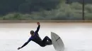 Seorang pria asik berselancar menikmati gelombang buatan yang ada di Surf Snowdonia, Conwy, North Wales, Kamis (3/9/2015).  Danau ini menjadi yang pertama sebagai Danau buatan komersial di dunia. (REUTERS/Andrew Yates)