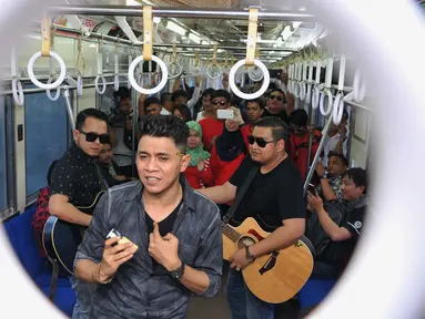 Band beraliran musik melayu, ST12 membawakan lagu saat berada di dalam gerbong kereta commuter, Jumat (18/9/2015).  Band ST 12 didapuk menjadi duta Kereta Api Indonesia (KAI). (Liputan6.com/Gempur M Surya)