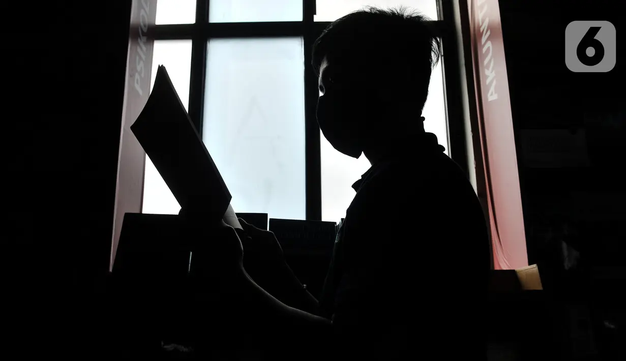 Pekerja membaca buku di sela bertugas menjaga toko JakBook, Pasar Kenari, Jakarta, Kamis (4/2/2021). Menurut salah satu pekerja, sebanyak 50 persen dari total buku koleksi JakBook terpaksa dikembalikan ke penerbit akibat merosotnya penjualan. (merdeka.com/Iqbal S. Nugroho)