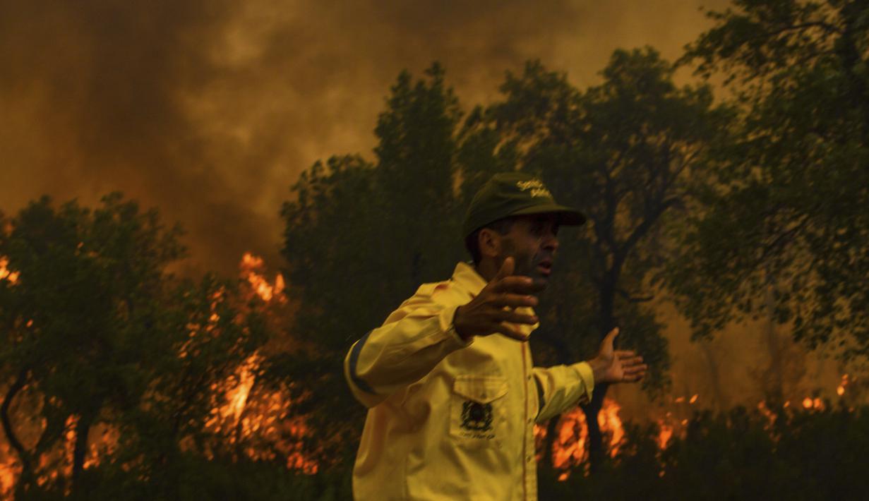 <p>Seorang petugas pemadam kebakaran bereaksi ketika mencoba untuk memadamkan api yang disebabkan suhu ekstrem di Larache, Maroko utara, Jumat (15/7/2022). Petugas pemadam kebakaran dan militer berjuang untuk menahan beberapa kebakaran hutan di Maroko utara, ketika ratusan warga mengungsi dari rumah mereka karena kobaran api yang melanda petak besar hutan pinus. (AP Photo)</p>