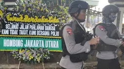 Dua Polisi Brimob berjaga di depan karangan bunga pasca kerusuhan napi teroris di Rutan Cabang Salemba Mako Brimob Kelapa Dua, Depok Kamis (10/5). (Merdeka.com/Arie Basuki)