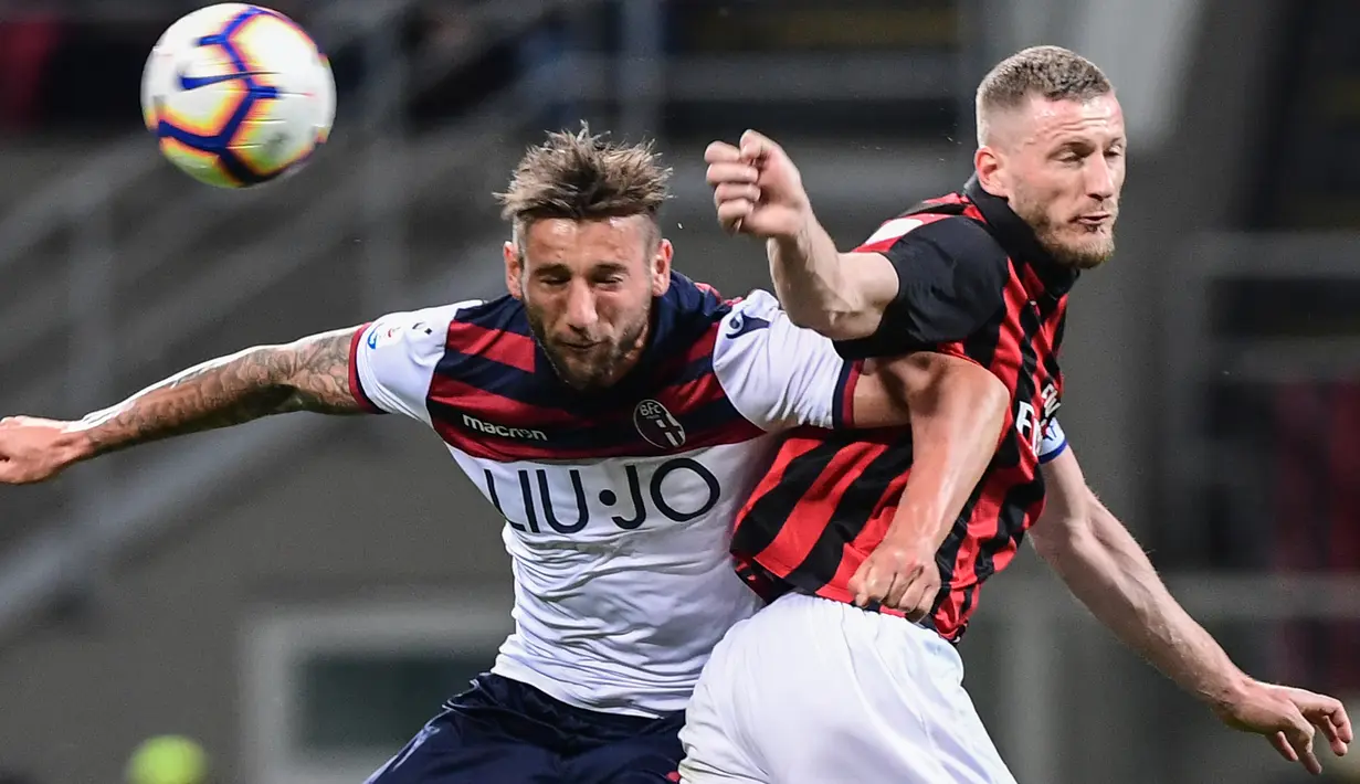 Pemain Bologna, Mitchell Dijks berebut bola dengan bek AC Milan, Ignazio Abate dalam laga pekan ke-35 Liga Italia di San Siro, Senin (6/5/2019). AC Milan berhasil mengatasi Bologna 2-1 demi memelihara asa mereka mengamankan tiket ke Liga Champions musim depan. (Miguel MEDINA/AFP)