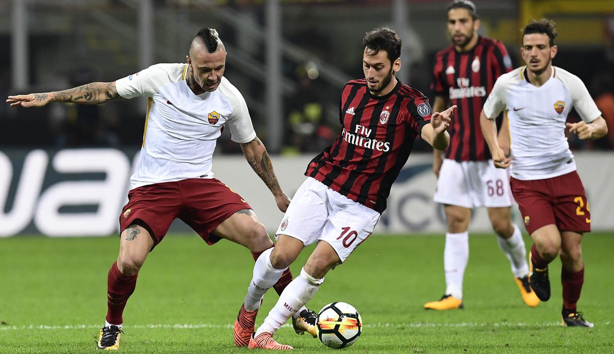Gelandang AC Milan, Hakan Calhanoglu, berebut bola dengan gelandang AS Roma, Radja Nainggolan, pada laga Serie A Italia di Stadion San Siro, Milan, Minggu (1/10/2017). Milan kalah 0-2 dari Roma. (AFP/Miguel Medina)
