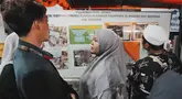 Keluarga santri memeriksa papan informasi sambil menunggu upaya penyelamatan bagi korban yang terjebak reruntuhan bangunan yang sedang dibangun di sebuah pondok pesantren di Sidoarjo, Jawa Timur, Rabu 1 Oktober 2025. (AP Photo/Achmad Ibrahim)