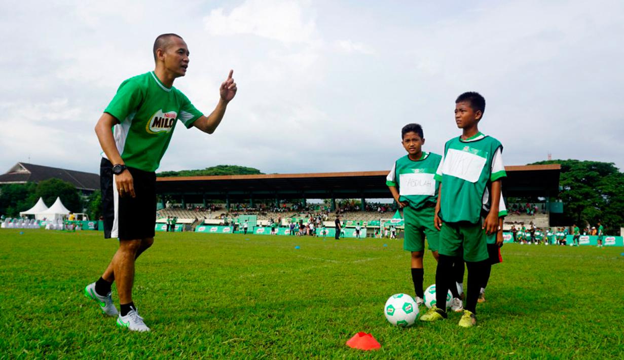 Kurniawan Dwi Yulianto (kiri) memberikan football clinic kepada anak-anak usia sekolah dasar di stadion Mini Universitas Sumut, Minggu (14/2/2016). Football clinic merupakan salah satu kegiatan di MILO Football Championship 2016. (Foto:Istimewa)
