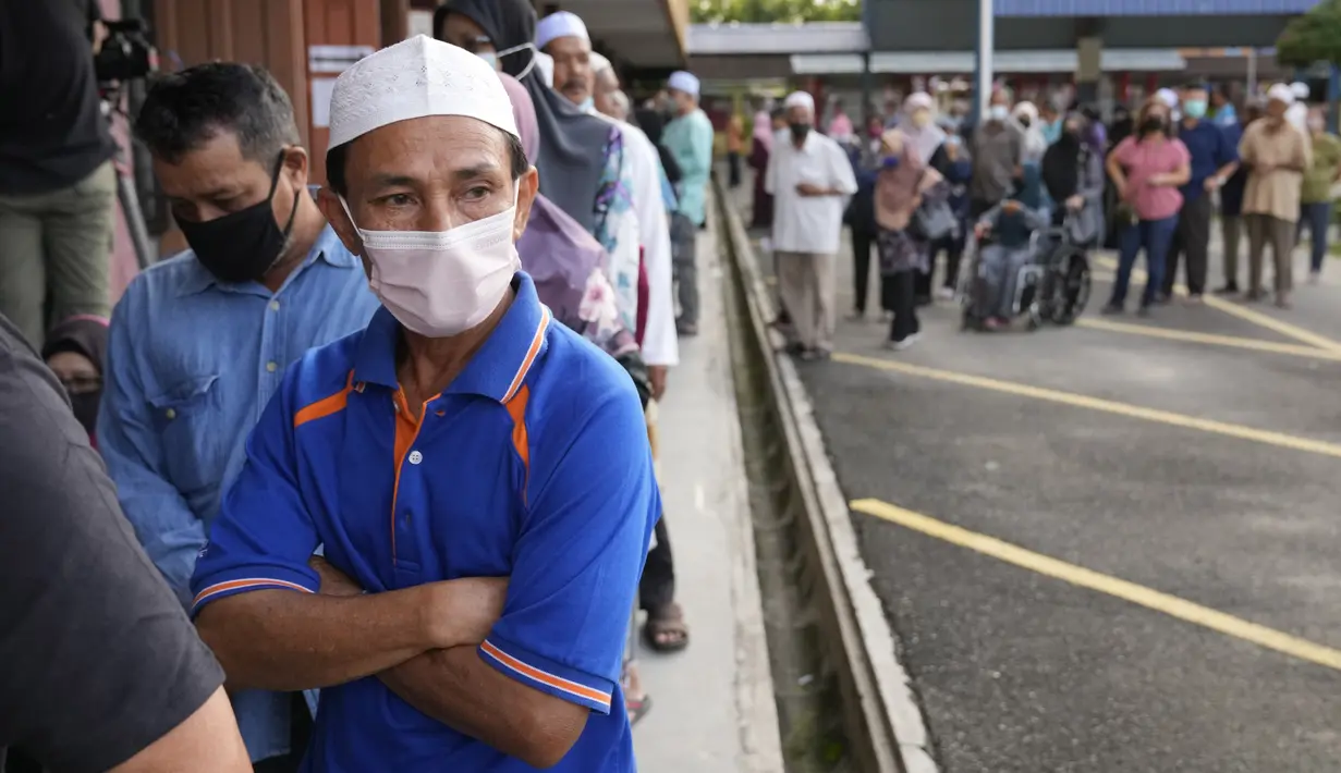 Orang-orang mengantre memberikan suara mereka selama pemilihan di sebuah tempat pemungutan suara di Seberang Perai, negara bagian Penang, Malaysia, Sabtu (19/11/2022). Pemilu 2022 digelar dengan koalisi yang sengit yaitu kandidat petahana Ismail Sabri Yaakob, pemimpin oposisi lama Anwar Ibrahim, dan mantan pemimpin Muhyiddin Yassin. (AP Photo/Vincent Thian)