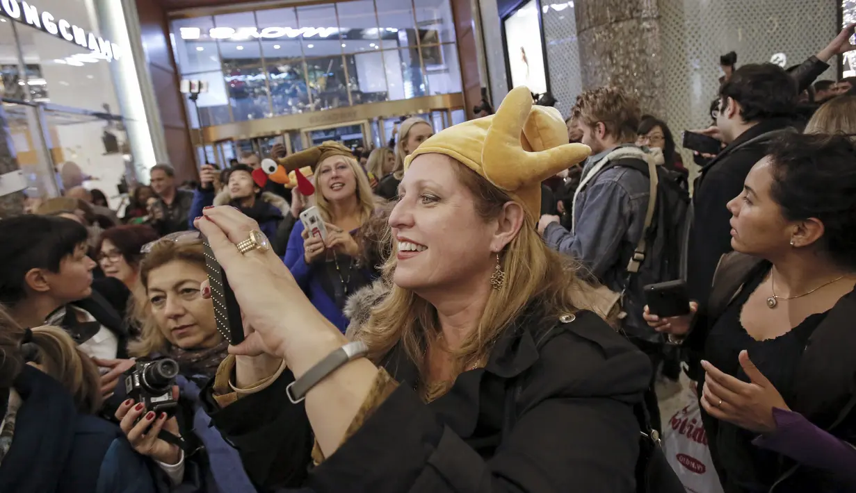 Seorang wanita mengabadikan gambar keramaian orang - orang berbelanja di Macy Herald Square, New York,(26/11). Black Friday adalah hari dimulainya musim belanja bagi warga Amerika menjelang Natal. (REUTERS/Andrew Kelly)