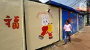Anak kecil berjalan di dekat mural kelinci di Kampung Haji Bona, Depok, Jawa Barat, Kamis (19/1/2023). Perayaan tahun baru Imlek dimulai pada hari pertama penanggalan Tionghoa yaitu tanggal 22 Januari 2023 dan berakhir pada Cap Go Meh. (merdeka.com/Arie Basuki)