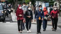 Sejumlah warga menyeberang jalan di kawasan Jalan Thamrin, Jakarta, Selasa (17/5/2022). Presiden Joko Widodo atau Jokowi mengatakan, masyarakat diperbolehkan tidak menggunakan masker jika sedang beraktivitas di luar ruangan atau area terbuka yang tidak padat orang. (Liputan6.com/Faizal Fanani)