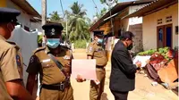 Hakim Sri Lanka Wasantha Ramanayake (kanan) dan petugas polisi sedang di luar rumah tempat seorang gadis dicambuk sampai mati di Delgoda, pada 28 Februari 2021. (Foto: AP Photo / Sudath Pubudu Keerthi).