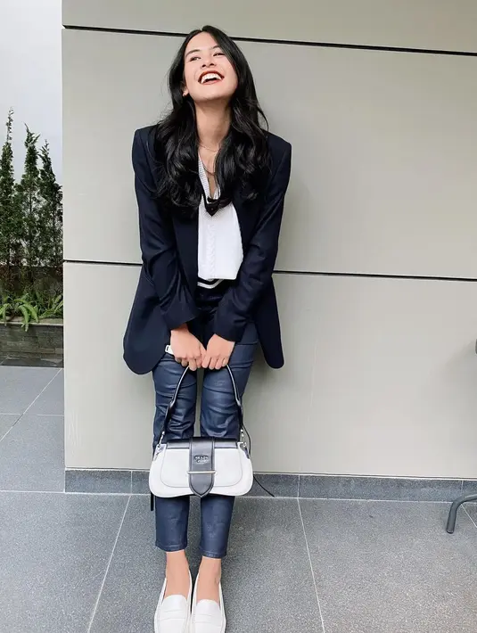 Outfit smart casual menjadi salah satu jenis look yang kerap dipilih Maudy Ayunda. Mengenakan knitwear putih yang dilapisi blazer dan dipadukan dengan jeans dan loafer putih. Melengkapi outfit hitam putihnya, Maudy Ayunda menjinjing Prada Sidonie Shoulder Bag yang dibanderol berkisar Rp28-50jutaan