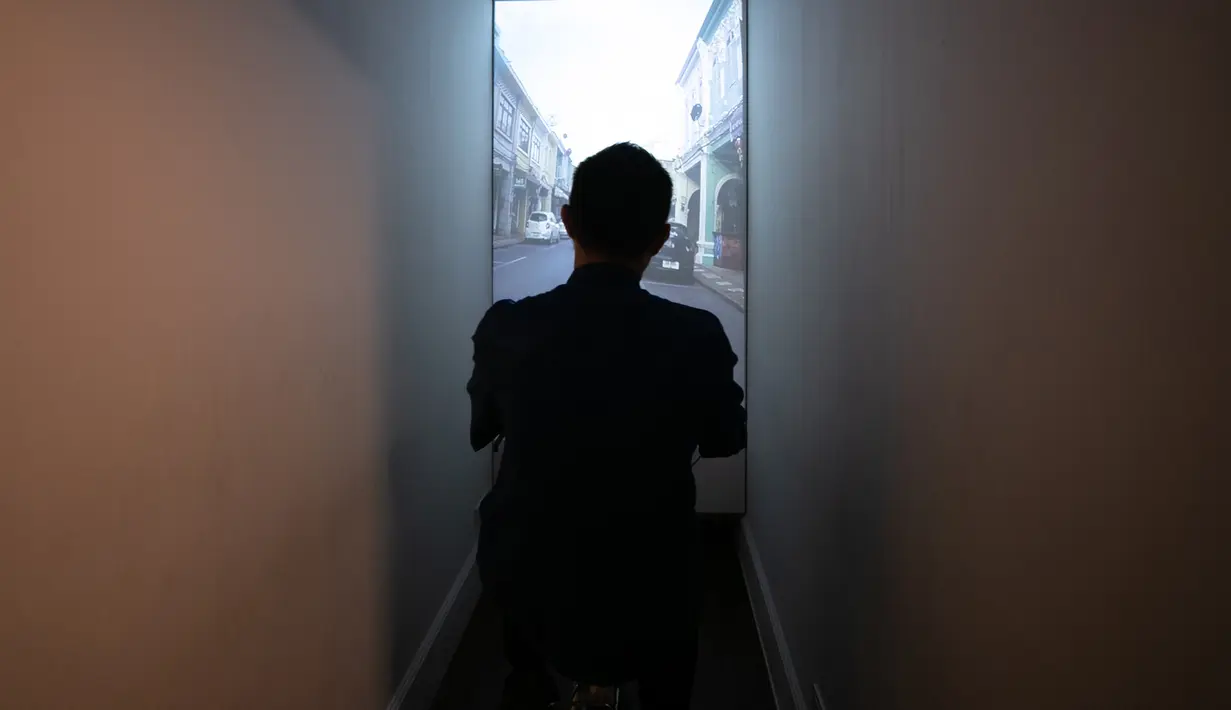 Seorang pria menjajal tur sepeda virtual mengelilingi Kota Tua Phuket di Museum Peranakan Phuket di Phuket, Thailand, pada 12 September 2020. Museum ini menampilkan sejarah dan budaya Peranakan melalui berbagai koleksi benda pameran dan teknologi. (Xinhua/Zhang Keren)