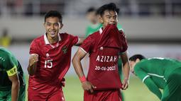 Pemain Timnas Indonesia U-23, Pratama Arhan (kanan) melakukan selebrasi setelah mencetak gol kedua ke gawang Timnas Turkmenistan U-23 dalam pertandingan grup K Kualifikasi Piala Asia U-23 2024 yang berlangsung di Stadion Manahan, Solo, Selasa (12/9/2023). Setelah mencetak gol, Arhan sontak mengangkat baju dan memamerkan nama istrinya, Azizah Salsha, dan tanggal pernikahan mereka. (Bola.com/Arief Bagus)