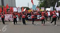 Massa buruh berjalan menuju Istana Negara saat aksi Hari Buruh di Jakarta, Senin (1/5). Dalam aksinya para buruh meminta sistem kerja kontrak dan upah rendah dihapus. (Liputan6.com/Helmi Afandi)