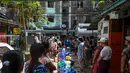 Orang-orang berbaris untuk mengisi wadah dengan air di Yangon, Myanmar (14/3/2022). Ribuan orang menghadapi kekurangan air karena pemadaman listrik di kota tersebut. (AFP/STR)