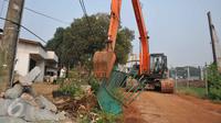 Petugas mengoperasikan alat berat membongkar bangunan di kawasan Pangkalan Jati, Bekasi, Jawa Barat, Kamis (8/10). Pembongkaran dilakukan untuk mempersiapkan lahan pembangunan Jalan Tol Bekasi Cawang Kampung Melayu (Becakayu).(Liputan6.com/Gempur M Surya)