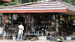 Seorang pedagang dengan berbagai barang tua dan antik di kawasan penjual barang antik dan kuno di Jalan Surabaya, Jakarta, Minggu (10/9). Banyak kios yang dikenal sebagai langganan berburu bagi para kolektor barang tua. (Liputan6.com/Gempur M. Surya)