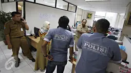 Petugas Ditkrimsus Polda Metro Jaya berbincang dengan sejumlah pegawai saat melakukan penggeledahan di kantor Dinas Pendapatan Daerah (Dispenda) DKI Jakarta, Selasa (12/1). (Liputan6.com/Immanuel Antonius)