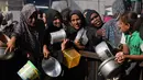 Warga Palestina menunggu bantuan gula dan beras di dapur umum di Khan Younis, Jalur Gaza selatan, Jumat, 31 Oktober 2025. Setiap harinya, ratusan warga, termasuk wanita, anak-anak, dan lansia, terlihat mengantre panjang di dapur umum dan dapur amal yang ada. (AP Photo/Abdel Kareem Hana)