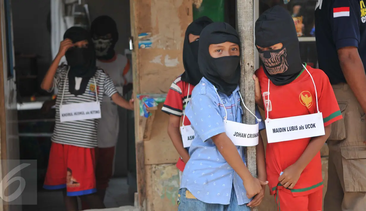 Sejumlah bocah dihadirkan untuk melakukan reka ulang pembunuhan bocah di dalam kardus, Jakarta, Selasa (20/10/2015). Proses rekonstruksi menjadi tontonan warga sekitar. (Liputan6.com/Gempur M Surya)