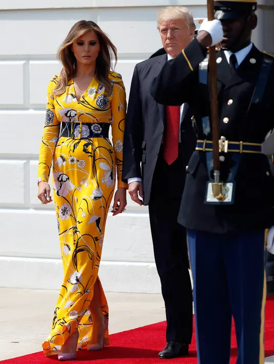 Ibu Negara AS, Melania Trump mendampingi Presiden AS Donald Trump menyambut kedatangan PM India, Narendra Modi di Gedung Putih, Senin (26/6). Melania memilih gaun panjang bermotif bunga dari desainer Emilio Pucci untuk acara tersebut. (AP/Alex Brandon)