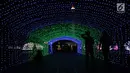 Pengunjung berjalan di lorong cahaya lampion saat Festival of Light di Monumen Nasional (Monas), Jakarta, Rabu (14/8/2019). (merdeka.com/Iqbal S. Nugroho)