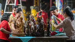 Tradisi bersih-bersih rupang atau patung dewa (para suci) mewarnai persiapan perayaan Tahun Baru Imlek 2577 Kongzili di Kuil Hong San Ko Tee, Surabaya, Jawa Timur, pada Rabu 11 Februari 2026. Tampak dalam foto, para sukarelawan membersihkan patung-patung dewa di Kuil Hong San Ko Tee, Surabaya, Jawa Timur, pada Rabu 11 Februari 2026. (JUNI KRISWANTO/AFP)