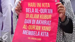 Seorang demonstran membawa poster saat aksi menuntut Ahok agar diadili di Semarang, Jumat (4/11). Gubernur DKI diduga telah melakukan penistaan agama di Kepulauan Seribu. (Liputan6.com/Gholib)