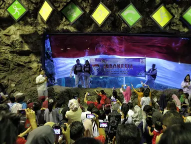 Penyelam membentangkan spanduk saat pengibaran bendera Merah Putih untuk memperingati HUT Ke-73 RI di SeaWorld Ancol, Jakarta, Jumat (17/8). Pengibaran bendera melibatkan para penyelam profesional dan artis peran Marsha Aruan. (Liputan6.com/Faizal Fanani)