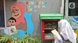 Pelajar membaca buku di Kampung Literasi RW 08, Jatipulo, Palmerah, Jakarta Barat, Kamis (30/1/2020). Kampung Literasi ini memiliki 5 kotak berisi beragam buku yang ada di sejumlah titik, berbekal konsep kejujuran disebar di sepanjang kampung. (Liputan6.com/Herman Zakharia)