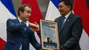 Menteri Pertahanan Republik Indonesia, Sjafrie Sjamsoeddin (kanan) menerima cinderamata dari Menhan Prancis, Sebastian Lecornu, dalam pertemuan mereka di Gedung Kementerian Pertahanan (Kemenhan), Jalan Medan Merdeka Barat, Jakarta Pusat, Jumat (31/1/2025). (ADITYA AJI/AFP)