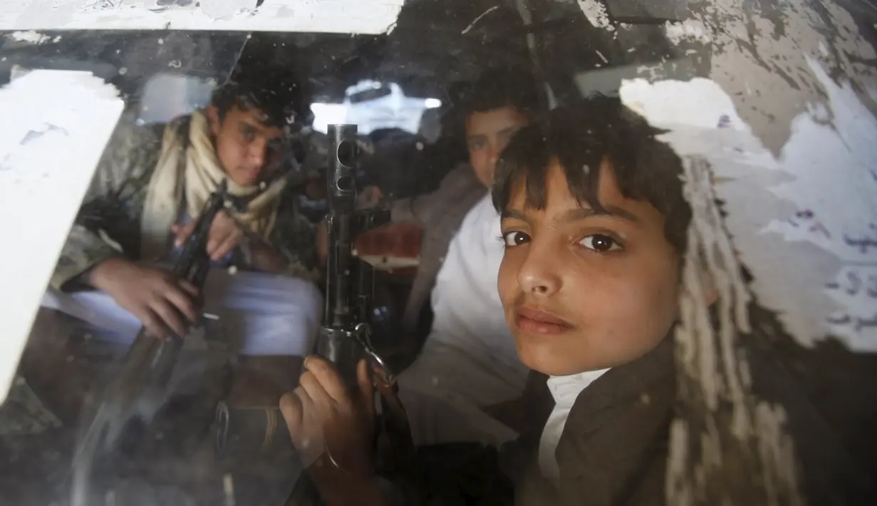 Anak - anak kelompok houthi memegang senjata selama ikuti demonstrasi di jalanan Ibukota Yaman, Sanna, Jumat, (20/11). (REUTERS/Khaled Abdullah)