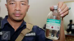 Petugas menunjukkan botol obat yang disita dalam penggerebekan dua klinik aborsi ilegal di kawasan Cikini, Jakarta, Rabu (24/2). Sebanyak 9 orang diduga pelaku praktik aborsi sekitar 5.400 janin bayi diamankan petugas. (Liputan6.com/Gempur M Surya)