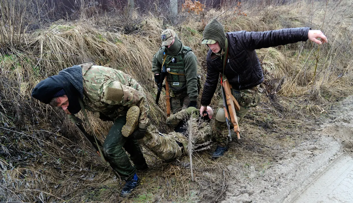 Warga sipil melakukan penyelamatan prajurit yang terluka saat mengikuti sesi pelatihan militer oleh Right Sector dekat Lviv, Ukraina, 24 Februari 2023. (AP Photo/Mykola Tys)