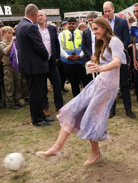 Kate Middleton saat menendang bola selama kunjungan ke Cambridgeshire County Day sebagai bagian dari perayaan Platinum Jubilee Ratu Elizabeth di Newmarket Racecourse (23/6/2022). Terlihat bersemangat menendang bola ke sasaran di depan orang banyak. (AFP/Pool/Paul Edwards)