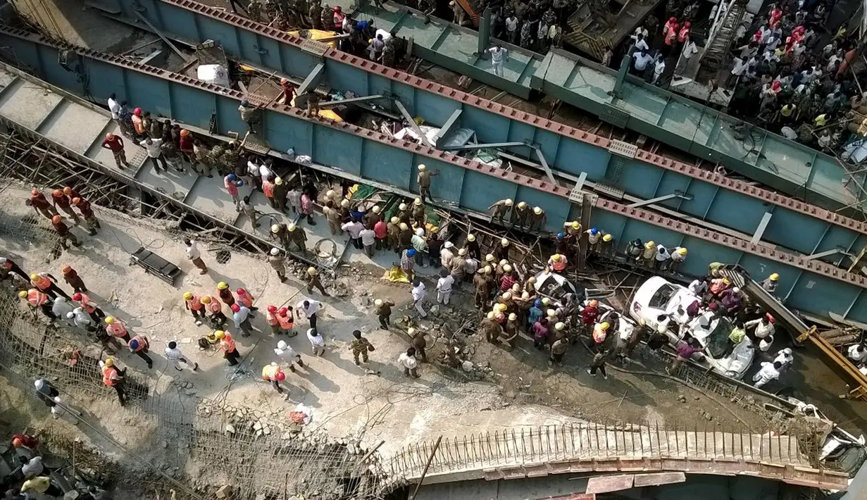 Sejumlah orang berkumpul di lokasi ambruknya sebuah jalan layang di Kolkata, India, Kamis (31/3). Saksi mengatakan tim penyelamat terpaksa menggunakan tangan untuk mencoba menyelamatkan korban yang terperangkap. (REUTERS/Rupak De Chowdhuri)
