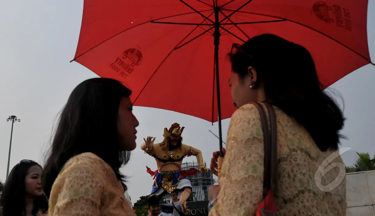 Sejumlah warga meramaikan acara pawai ogoh-ogoh di kawasan Monumen Nasional (Monas), Jakarta, Jumat (20/3/2015). Pawai tersebut merupakan rangkaian dari prosesi menjelang Hari raya Nyepi Tahun Saka 1937. (Liputan6.com/Johan Tallo) 