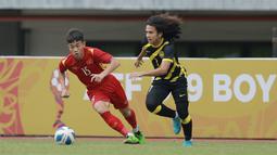 Pemain Timnas Vietnam U-19, Nguyen Dinh Bac (kiri) berusaha melewati pemain Timnas Malaysia U-19, Muhammad Najmudin Akmal Kamal Akmal pada laga semifinal Piala AFF U-19 2022 yang berlangsung di Stadion Patriot Candrabhaga, Bekasi, Rabu (13/07/2022). (Bola.com/M Iqbal Ichsan)