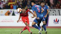 Gelandang Timnas Indonesia U-22, Marselino Ferdinan (kiri) berusaha melewati pemain Thailand, Songchai Thongcham pada laga final cabor sepak bola SEA Games 2023 di National Olympic Stadium, Phnom Penh, Kamboja, Selasa (16/5/2023). (Bola.com/Abdul Aziz)