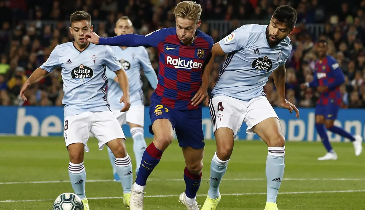 Gelandang Barcelona, Frenkie de Jong (tengah) membawa bola dari kawalan dua pemain Celta Vigo, Nestor Araujo dan Fran Beltran pada pertandingan lanjutan La Liga Spanyol di stadion Camp Nou (9/11/2019). Barcelona menang telak 4-1 atas Vigo. (AP Photo/Joan Monfort)