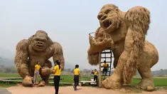 Para siswa berfoto dengan patung King Kong raksasa yang terbuat dari jerami di Huay Teung Tao Lake, Don Kaeo, Chiang Mai, Thailand, Rabu (3/4). Tempat ini merupakan satu dari banyak spot foto instagramable di Chiang Mai. (Lillian SUWANRUMPHA/AFP)