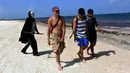 Seorang pria muda yang menyamar sebagai malaikat maut berkeliling pantai Puerto Morelos di Puerto Morelos, Quintana Roo, Meksiko, Sabtu (1/8/2020). Pria itu meminta wisatawan dan penduduk setempat kembali ke rumah karena pantai masih tertutup bagi pengunjung di tengah COVID -19. (ELIZABETH RUIZ/AFP)