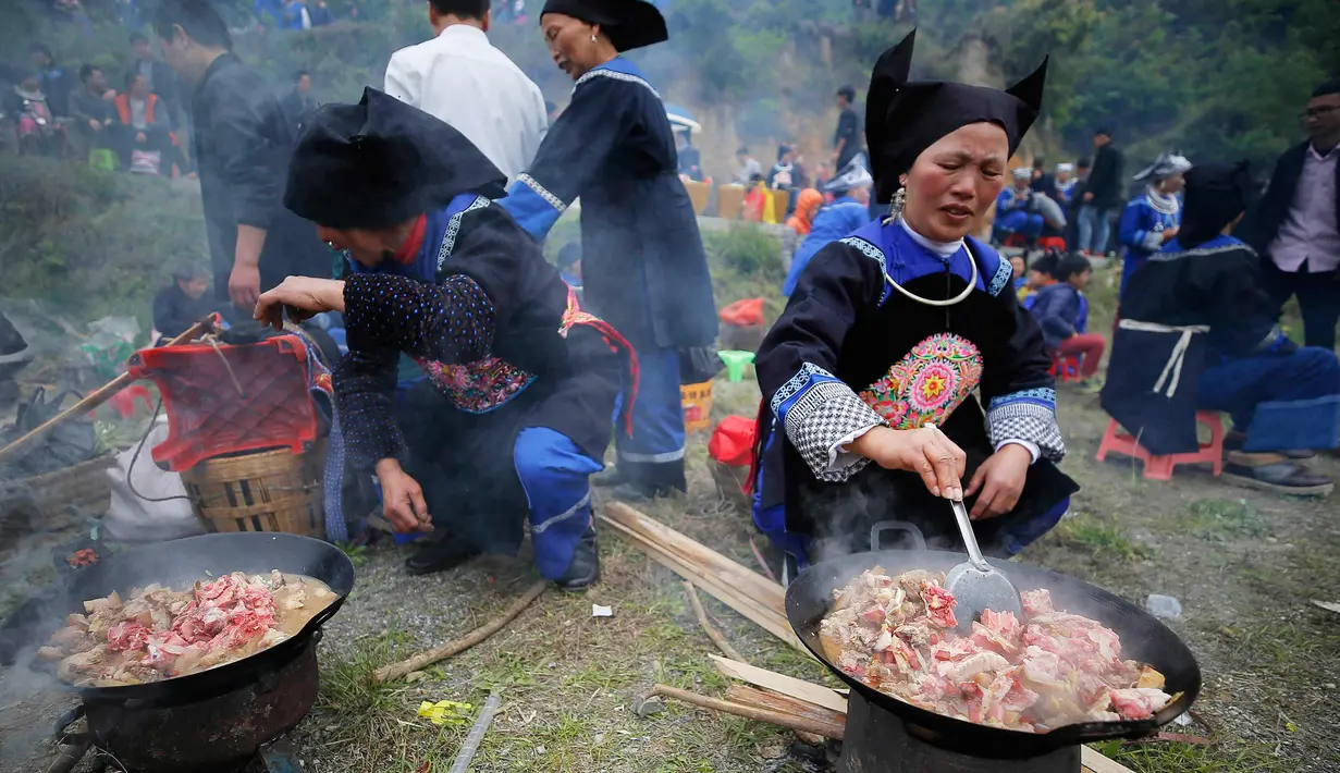 Orang-orang dari etnis minoritas Miao menyiapkan makanan setelah upacara pengorbanan untuk dewa gunung di Jianhe di provinsi Guizhou barat daya China (15/4). (AFP Photo/China Out)