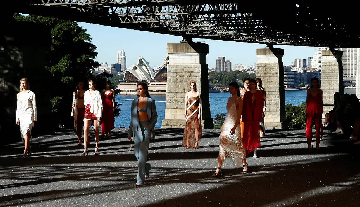 Sejumlah model berpose saat memperagakan busana Manning Cartell di bawah jembatan Sydney Harbour Bridge dalam acara Australian Fashion week, 17 Mei 2016. (REUTERS/Jason Reed)