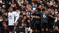 Para pemain Arsenal merayakan setelah pemain Fulham Antonee Robinson mencetak gol bunuh diri melewati kipernya pada pertandingan sepak bola Liga Inggris di Stadion Craven Cottage, London, 12 Maret 2023. Arsenal mengalahkan Fulham dengan skor 3-0. (AP Photo/Ian Walton)
