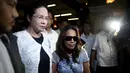 Maria Kristina Sergio (berkacamata hitam), perekrut terpidana mati Mary Jane dikawal petugas usai melakukan konferensi persi di Markas Polisi Camp Crame, kota Quezon, Filipina, Rabu (29/4/2015). (AFP PHOTO/NOEL CELIS)