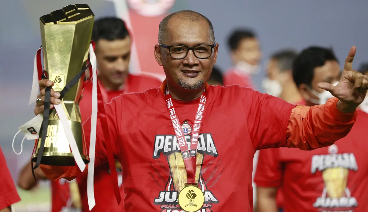 Pelatih Persija Jakarta, Sudirman, mengangkat trofi usai menjuarai Piala Menpora 2021 di Stadion Manahan, Solo, Minggu (25/4/2021). Persija mengalahkan Persib dengan agregat 4-1. (Bola.com/M Iqbal Ichsan)