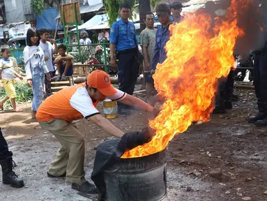 Petugas pemadam kebakaran mensosialisasikan cara pemadaman api kepada warga di kawasan Manggarai, Jakarta, Minggu (9/10). Sosialisasi yang disampaikan tentang cara penggunaan proteksi dan pecegahan pertama pada kebakaran. (Liputan6.com/Immanuel Antonius)